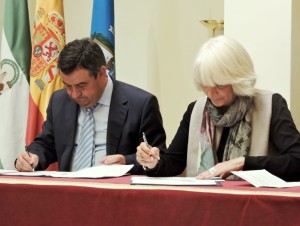 Momento en que ambos alcalde firman el convenio.