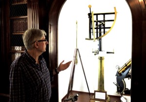 Frente a un expositor con instrumentos científicos antiguos.