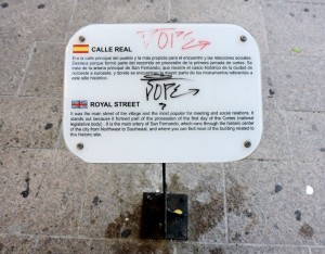 Placa con pintadas, en la calle Real.
